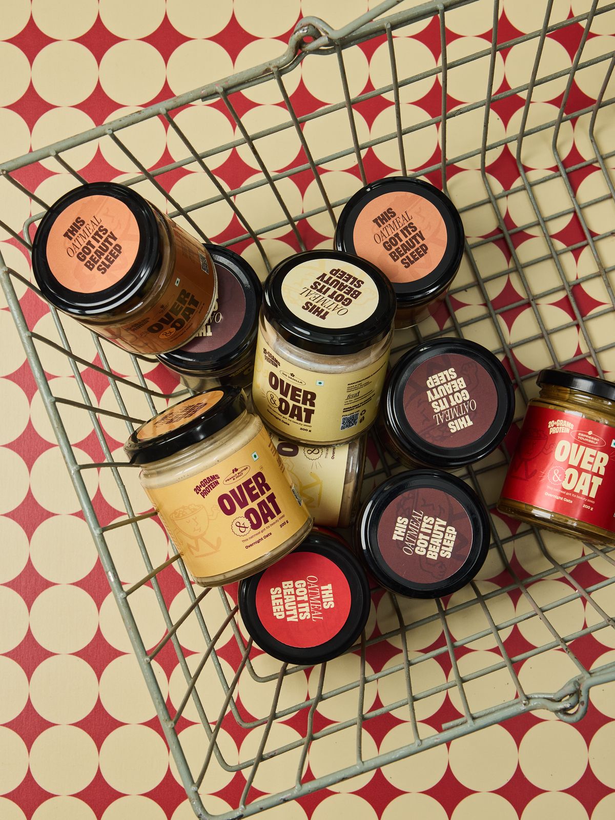 Over & Oat jars tumbled into a wire shopping basket on a red and cream polka-dot backdrop
